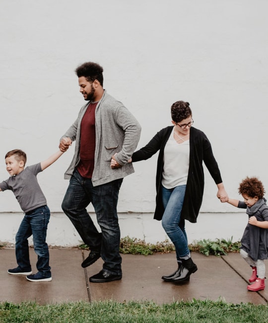 Family of four holding their hands